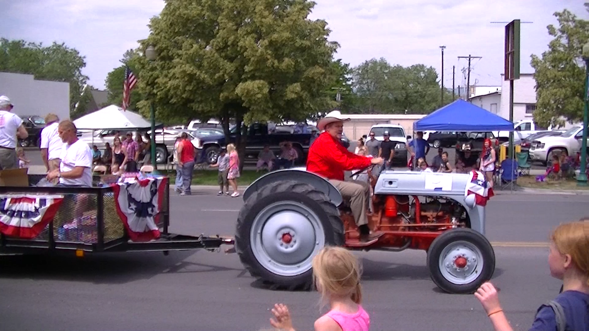 Mayor David Blackham driving vintage Ford tractor pulling the City Council Members in the 4th of July Parade