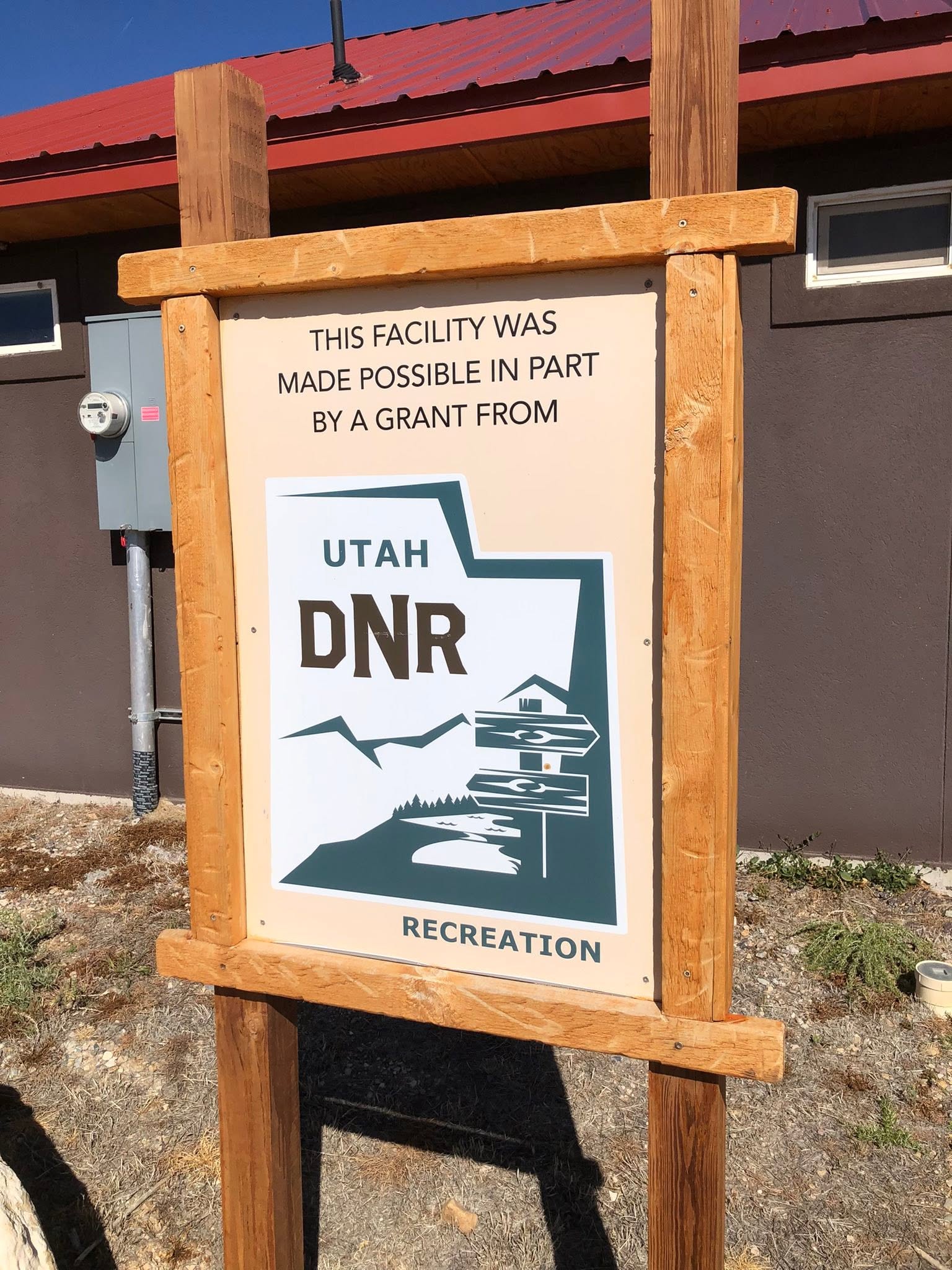 Wooden outdoor sign recognizing a Utah DNR Recreation grant that helped make the facility possible.