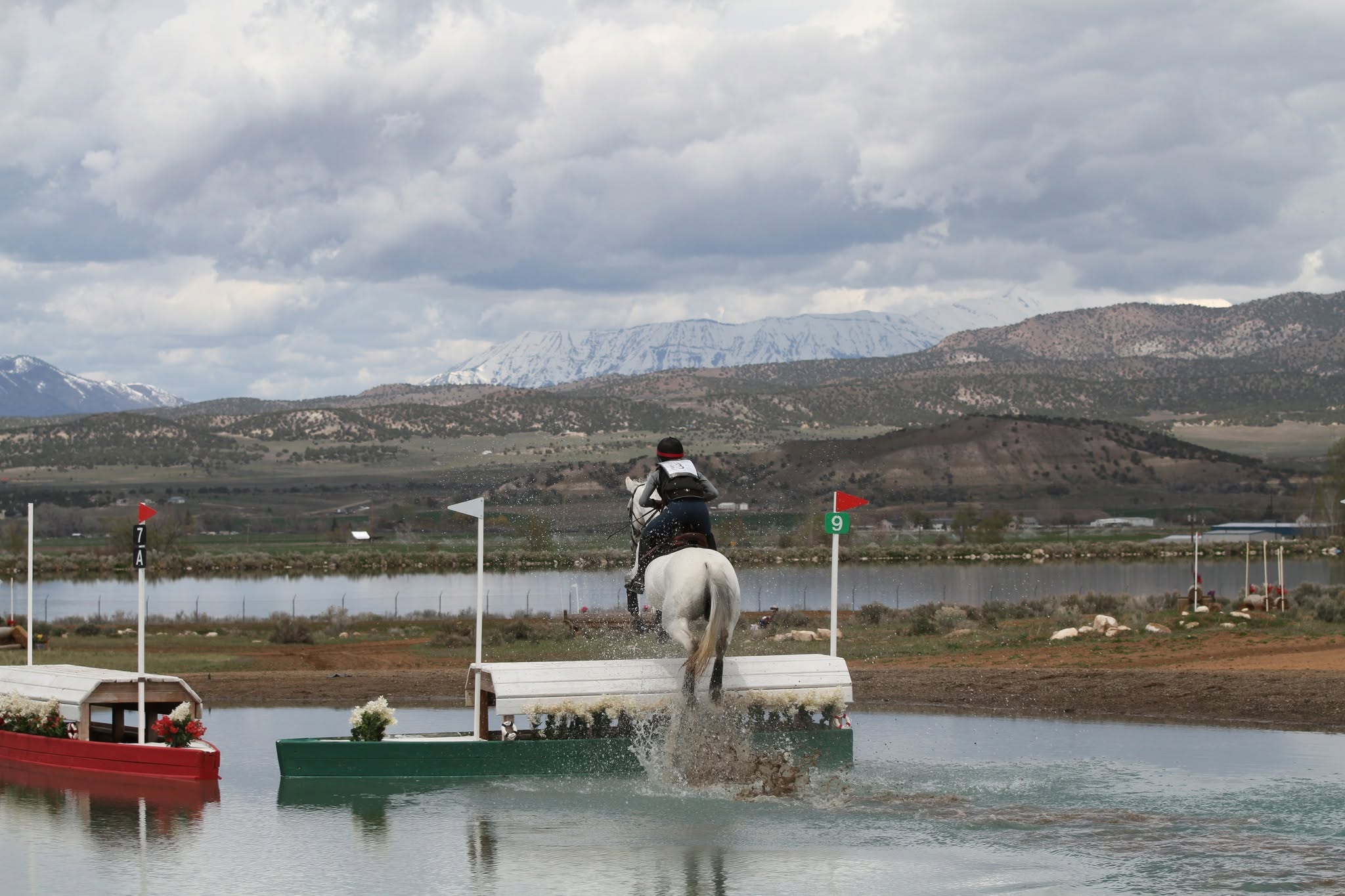 Outdoor eventing jump round with valley landscape beyond the arena.